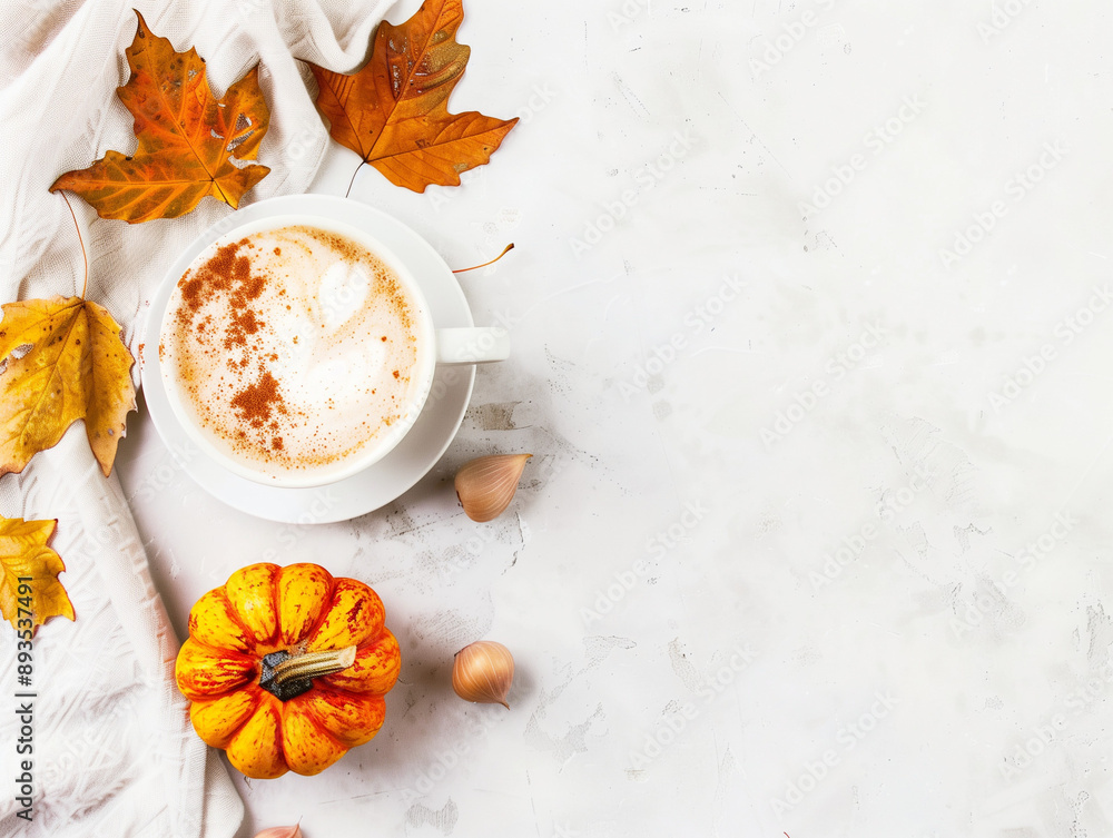 Mug of pumpkin spice latte surrounded by autumn leaves and pumpkin, with copy space. Seasonal drinks concept. Mug of pumpkin spice latte surrounded by autumn leaves and pumpkin, with copy space. Seasonal drinks concept.