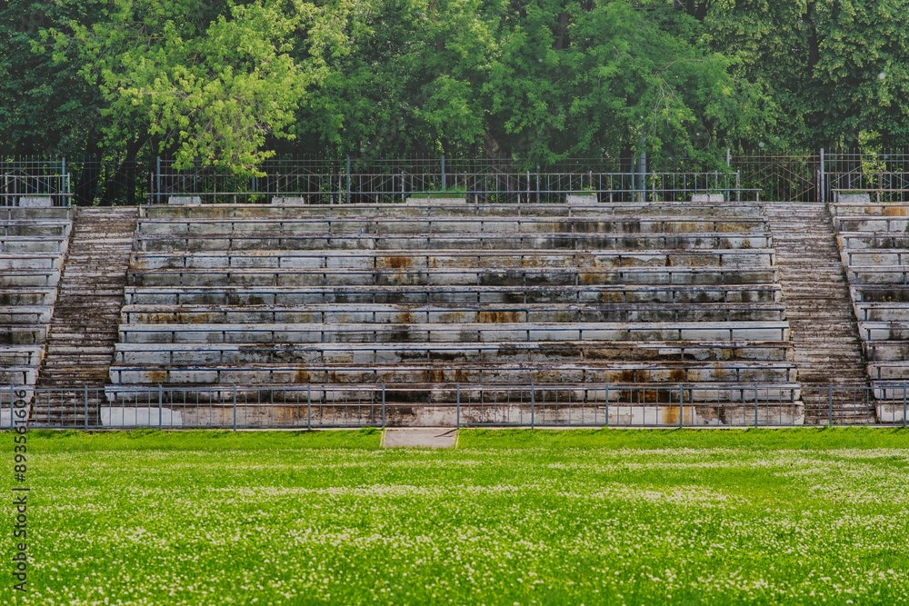 Obraz premium Empty stands of the old stadium. Concrete seats made from crumbling concrete in an abandoned sports stadium.