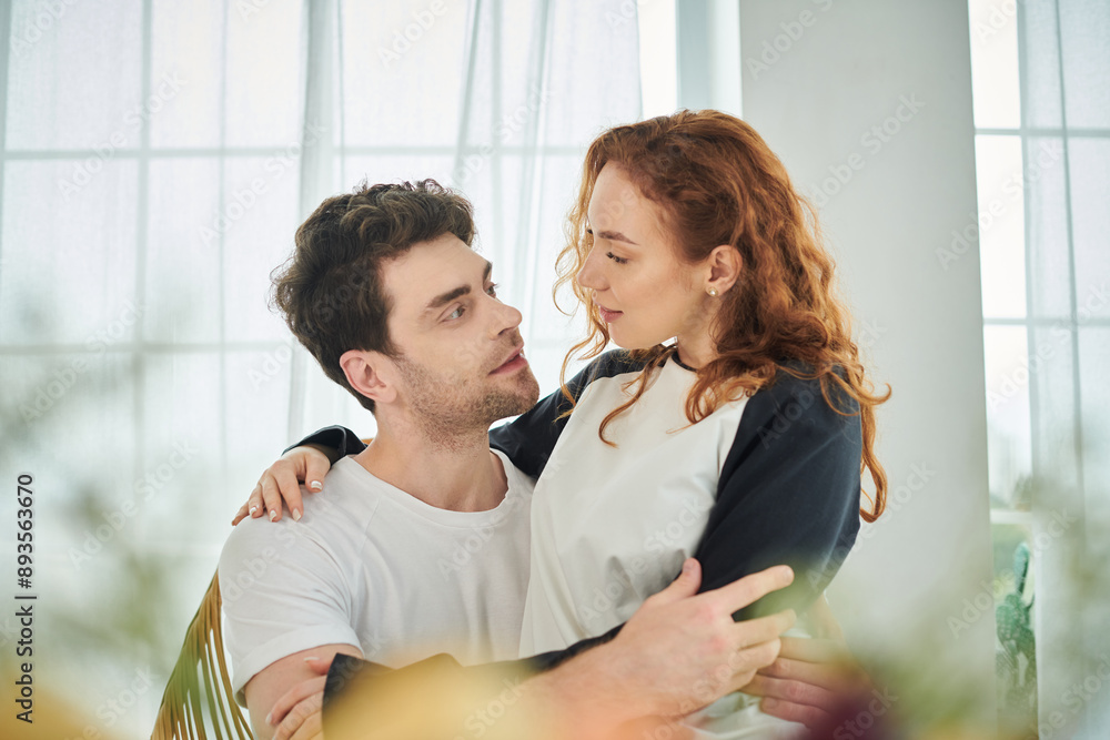 A man tenderly holds a woman in his arms as they share a moment of intimacy and affection. A man tenderly holds a woman in his arms as they share a moment of intimacy and affection.