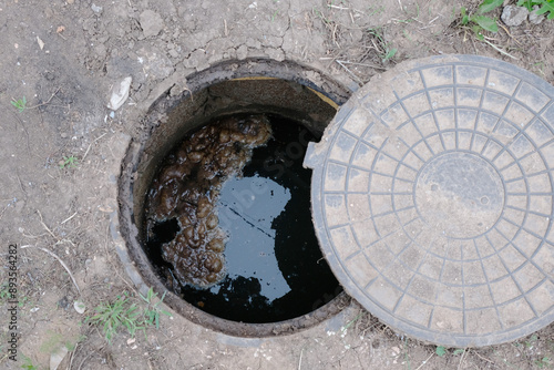 Overflowing septic tank of a country house, open hatch, top view