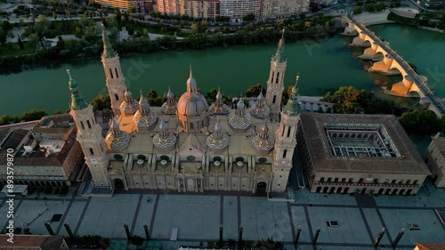 Zaragoza, Spain - Historic city center, aerial perspective. Drone starting from Cathedral of Zaragoza, going backwards and camera tilt up. Panoramic view of all city. Sunset point, orange reflections. photo