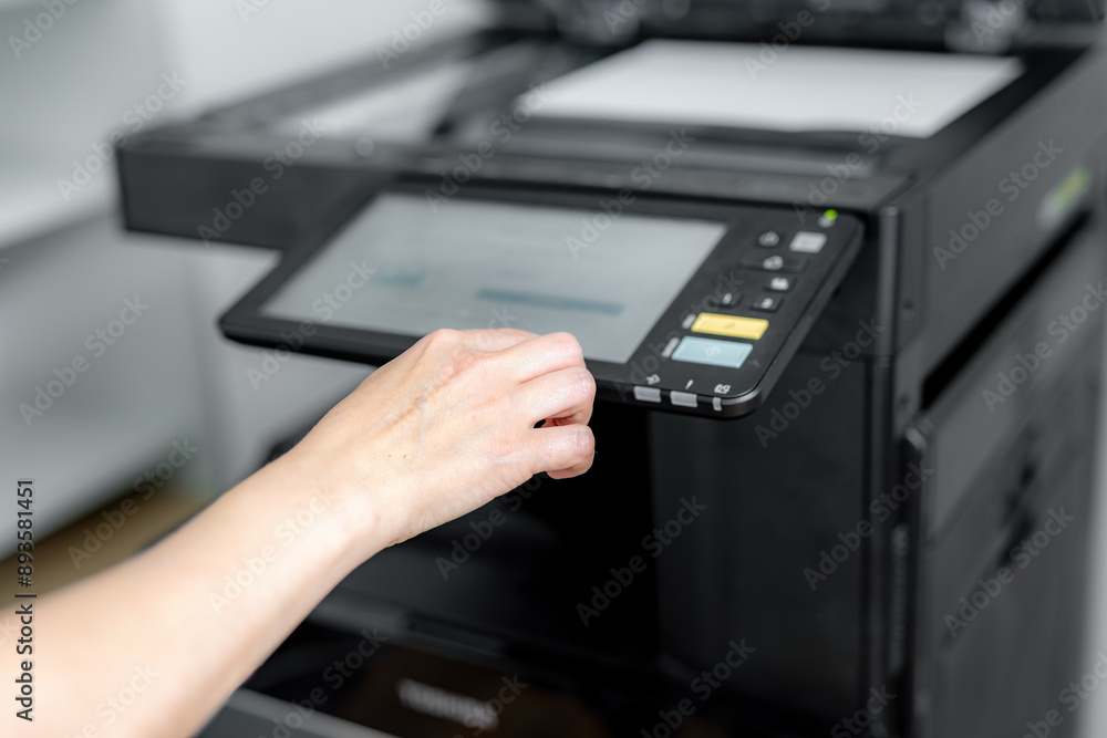 A girl sets up a photocopier to print and copy a document. A girl sets up a photocopier to print and copy a document.