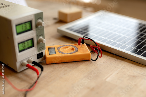 Solar battery and voltmeter on the electrician's desk. A device for measuring supply voltage on a solar panel. photo