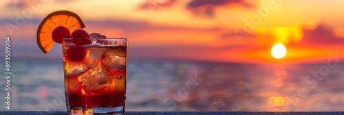 An iced summer cocktail isolated in front of a sunset over the sea 