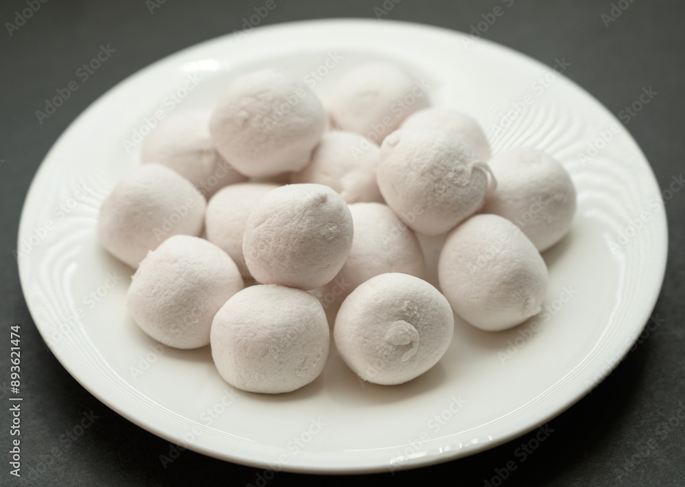 Marshmallows in white plate ob dark background. Marshmallows in white plate ob dark background.