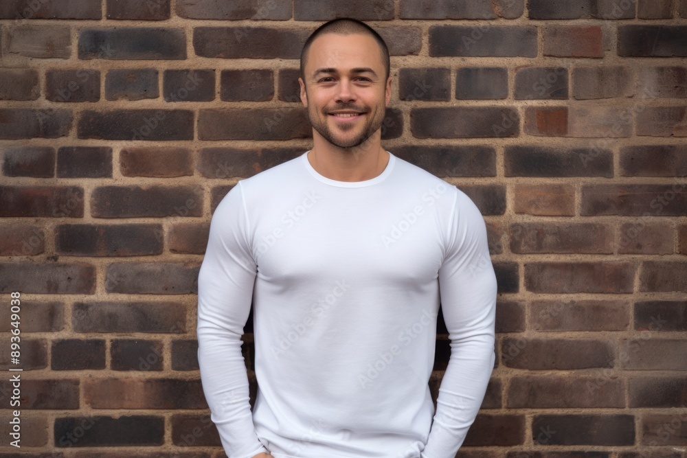 Portrait of a happy man in his 30s sporting a long-sleeved thermal undershirt in front of vintage brick wall Portrait of a happy man in his 30s sporting a long-sleeved thermal undershirt in front of vintage brick wall