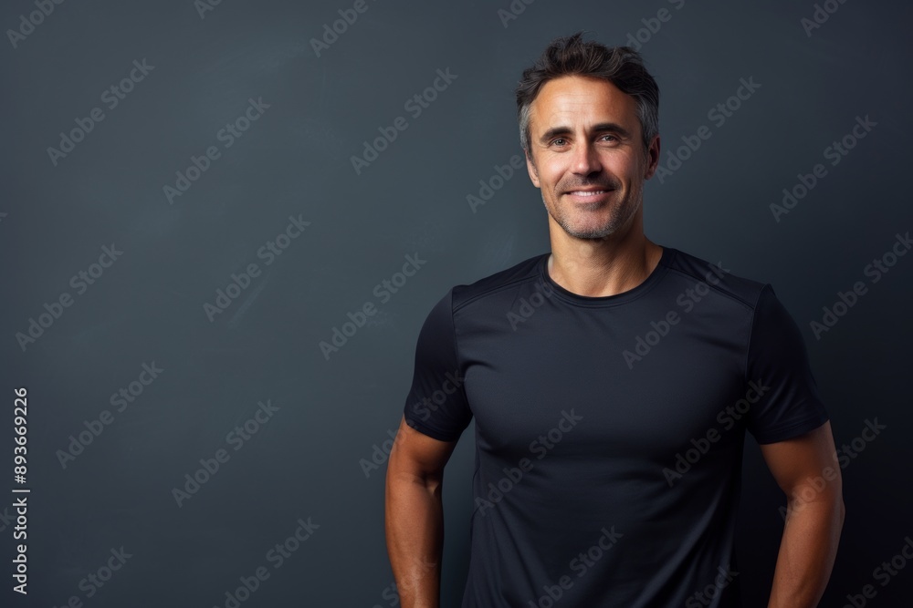 Portrait of a cheerful man in his 40s sporting a breathable mesh jersey while standing against modern minimalist interior Portrait of a cheerful man in his 40s sporting a breathable mesh jersey while standing against modern minimalist interior