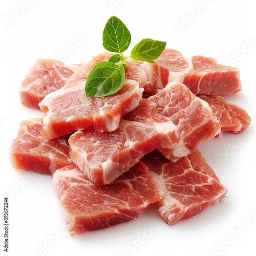 Fresh raw slices of pork meat arranged on a white background, garnished with green herbs for a perfect cooking preparation.