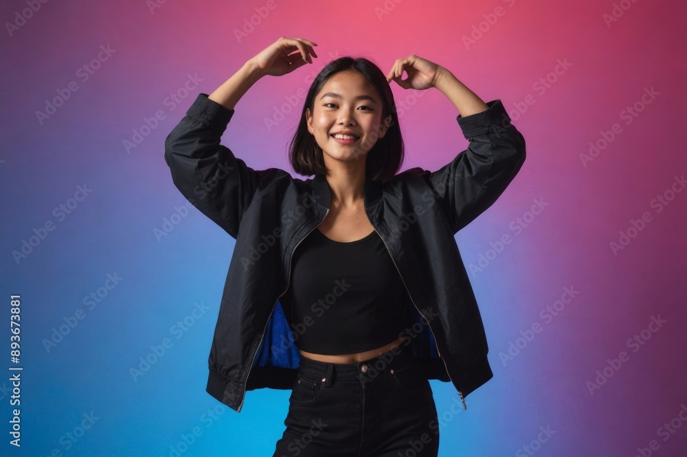 Portrait of a young Asian person dancing on a neon colored background Portrait of a young Asian person dancing on a neon colored background