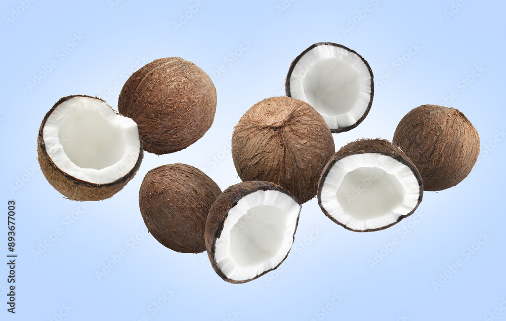 Many coconuts in air on light blue background Many coconuts in air on light blue background