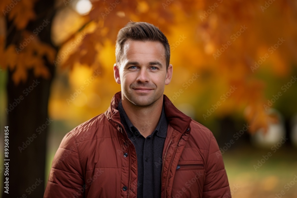 Portrait of a blissful man in his 30s donning a classy polo shirt over background of autumn leaves Portrait of a blissful man in his 30s donning a classy polo shirt over background of autumn leaves