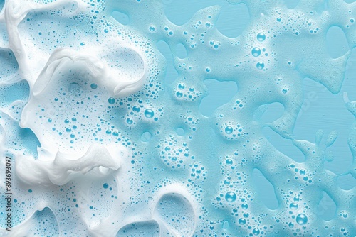 Foamy bubbles on blue surface Bath products bubbles Cleansing foam texture