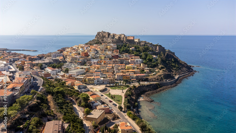 Aerial view of Castelsardo, a picturesque town of Sardinia, Italy. The historic town is perched on a rocky hill, surrounded by the Mediterranean Sea, featuring colorful buildings and a medieval castle Aerial view of Castelsardo, a picturesque town of Sardinia, Italy. The historic town is perched on a rocky hill, surrounded by the Mediterranean Sea, featuring colorful buildings and a medieval castle