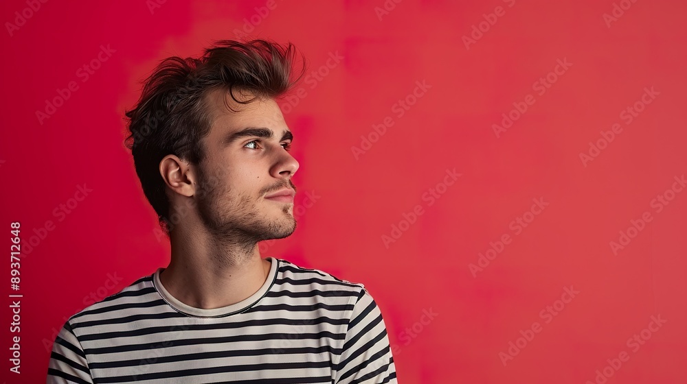 a portrait of a man in a striped shirt against a bold red background, emphasizing space for text or message placement a portrait of a man in a striped shirt against a bold red background, emphasizing space for text or message placement