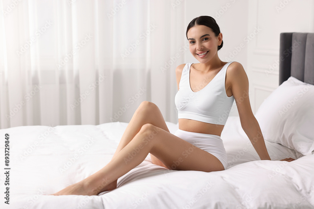 Smiling woman with perfect skin in underwear on bed, space for text. Body care Smiling woman with perfect skin in underwear on bed, space for text. Body care
