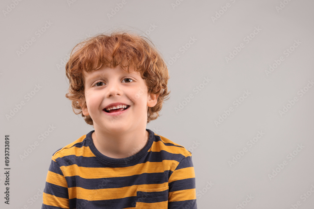 Portrait of cute little boy on grey background, space for text Portrait of cute little boy on grey background, space for text