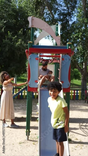 Latin family playing with his two children in a playground. Family with baby and child