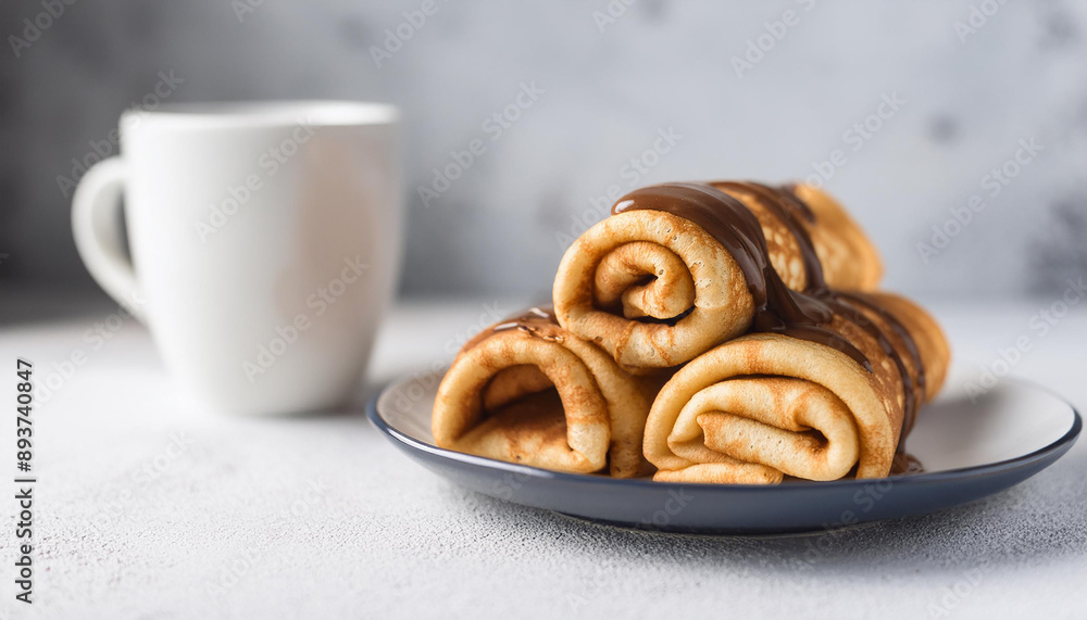 Rolled pancakes with chocolate ganache, coffee mug. Delicious breakfast. Cooking concept. Close-up. Rolled pancakes with chocolate ganache, coffee mug. Delicious breakfast. Cooking concept. Close-up.