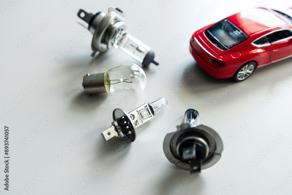red toy car with different car headlight h1 h4 h7 for repair. Automotive front light bulb red toy car with different car headlight h1 h4 h7 for repair. Automotive front light bulb
