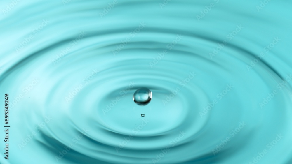 Freeze motion of splashing water drops on on light blue background Freeze motion of splashing water drops on on light blue background