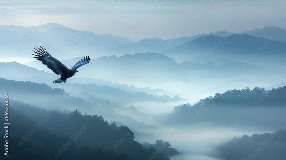 Fototapeta premium A high-resolution photograph featuring an eagle gliding effortlessly over a range of misty mountains