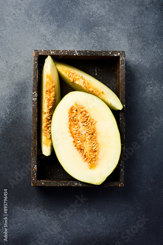 Fresh ripe and sweet melon sliced ​​in a wooden tray or box. Top view. photo