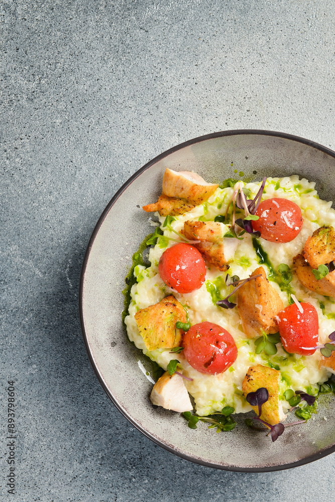Risotto with chicken fillet and cherry tomatoes. In a plate. Restaurant dish. Close up. Risotto with chicken fillet and cherry tomatoes. In a plate. Restaurant dish. Close up.