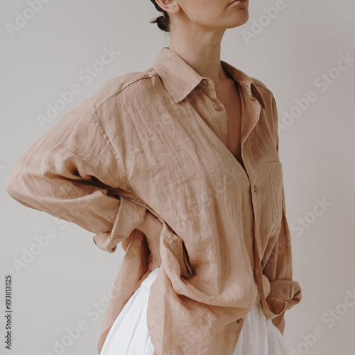 Fotografía Effortless elegance with a light brown, loose linen button-up shirt paired with a high-waisted white skirt