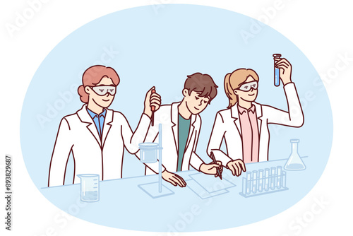 Students conduct experiments in laboratory doing scientific research to prepare for chemistry exam. Guys and girls in white coats stand at laboratory table with flasks filled with chemical reactions.