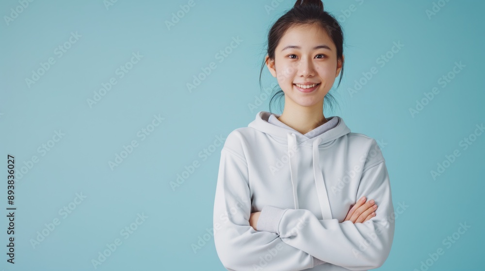 Friendly Asian Woman in Hoodie Posing Against Blue Background for Stock Photography, Design for Print, Poster Friendly Asian Woman in Hoodie Posing Against Blue Background for Stock Photography, Design for Print, Poster