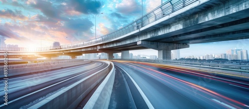 A highway bridge with blurred car lights in a city during sunset