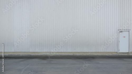 outer wall of a large warehouse with access doors for caregivers. The metal wall background of the spacious storage warehouse and caretaker entrance on the wall also provides space for messages.