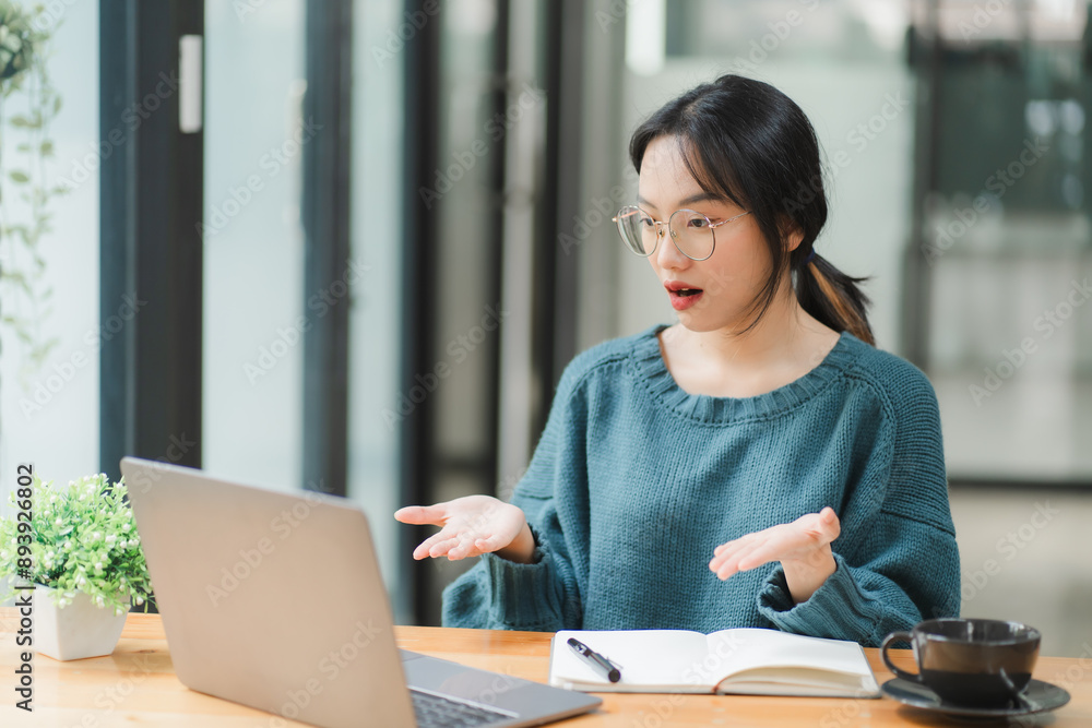 Shocked by the Screen: Young Asian woman, working remotely, reacts with surprise to her laptop, capturing the unexpected moments of online life. Shocked by the Screen: Young Asian woman, working remotely, reacts with surprise to her laptop, capturing the unexpected moments of online life.