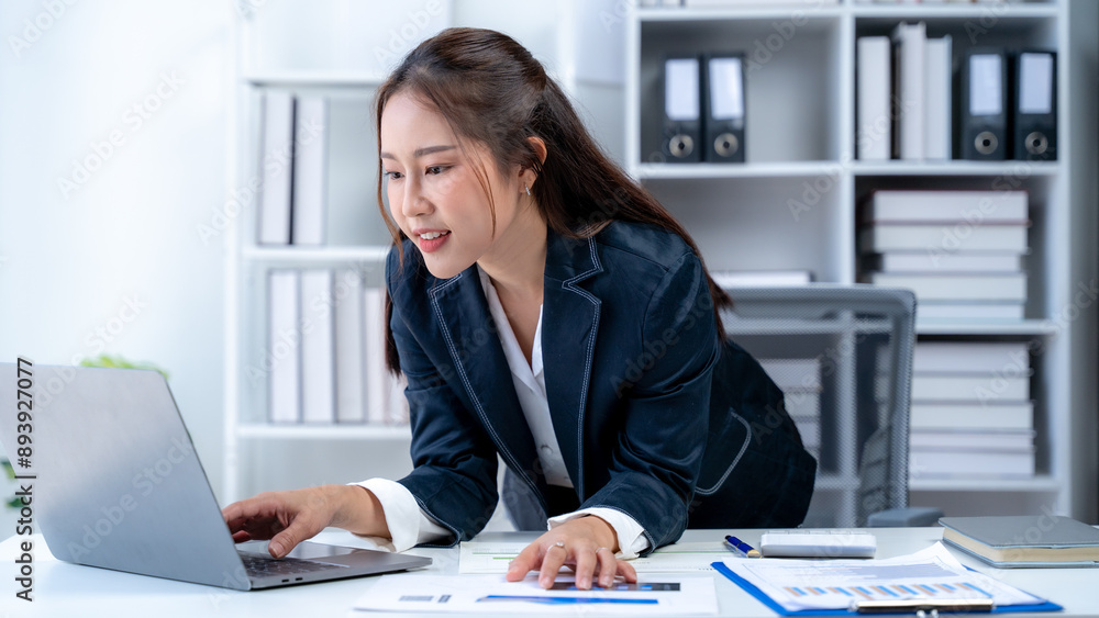 Happy Asian female employee at computer Happy Asian female employee at computer