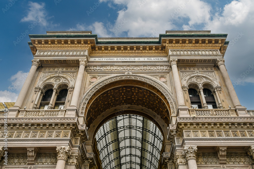 Fototapeta premium Low-angle view of the triumphal arch entrance to Galleria Vittorio Emanuele II (1877), Italy's oldest active shopping arcade, located in Piazza del Duomo, Milan, Lombardy, Italy