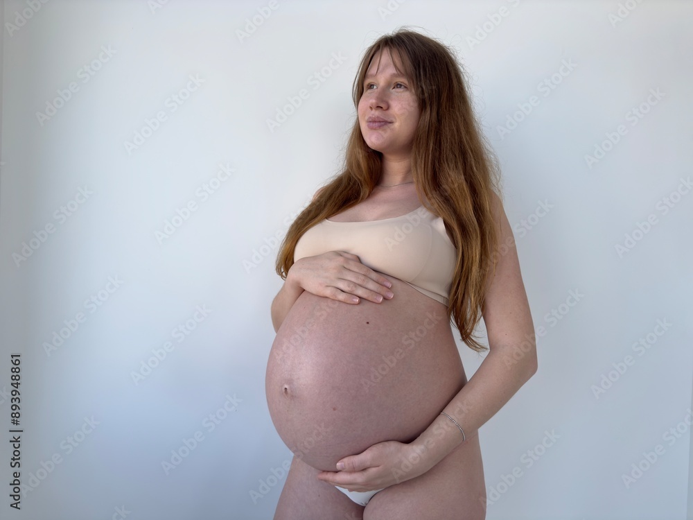 Happy pregnant young woman on white background in lingerie Happy pregnant young woman on white background in lingerie