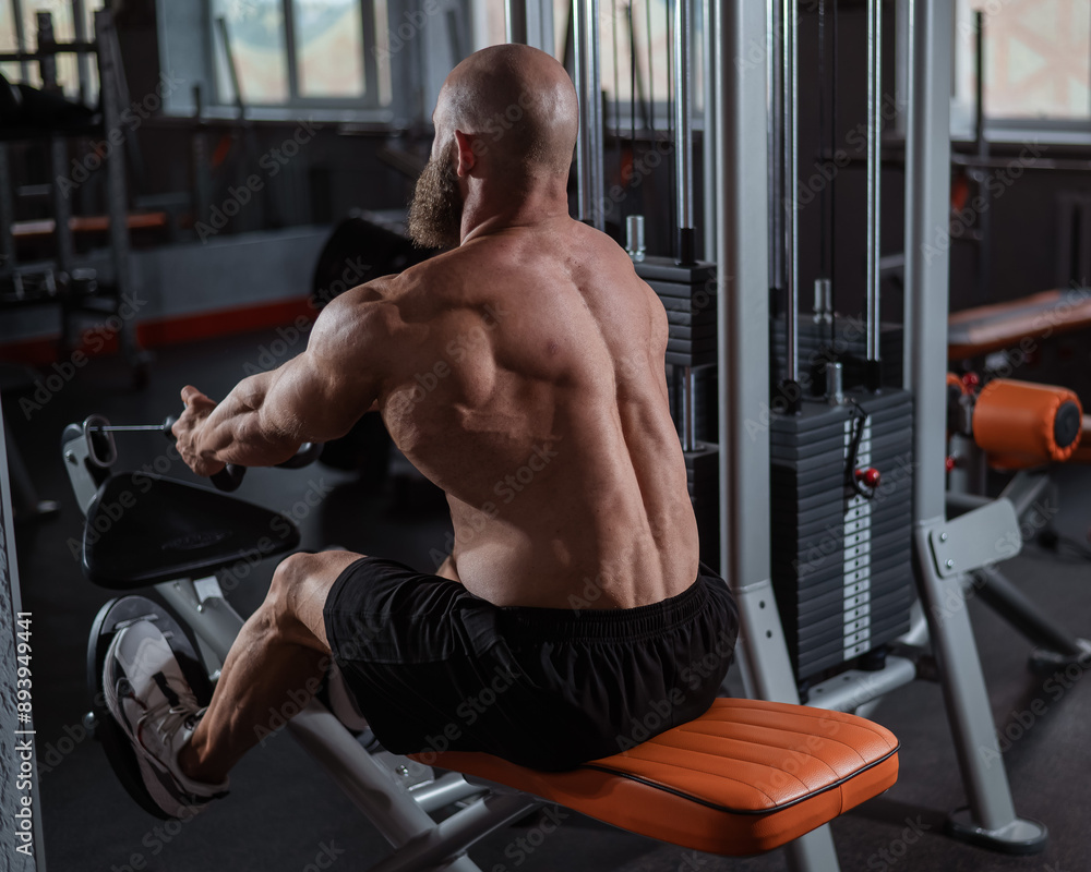 Naklejka premium Caucasian man doing rowing exercises on a rowing machine.