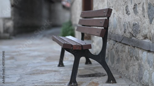 Wallpaper Mural Empty wooden bench scene set against the rustic backdrop of an old cobblestone street in Bulgaria, evoking feelings of solitude and reflection. Torontodigital.ca
