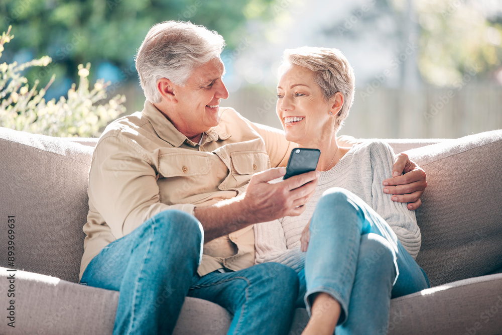 Senior, couple, smile and sofa with phone for browsing social media, streaming video and reading online news. Happy, elderly woman and man with mobile of communication, article or hug at house Senior, couple, smile and sofa with phone for browsing social media, streaming video and reading online news. Happy, elderly woman and man with mobile of communication, article or hug at house