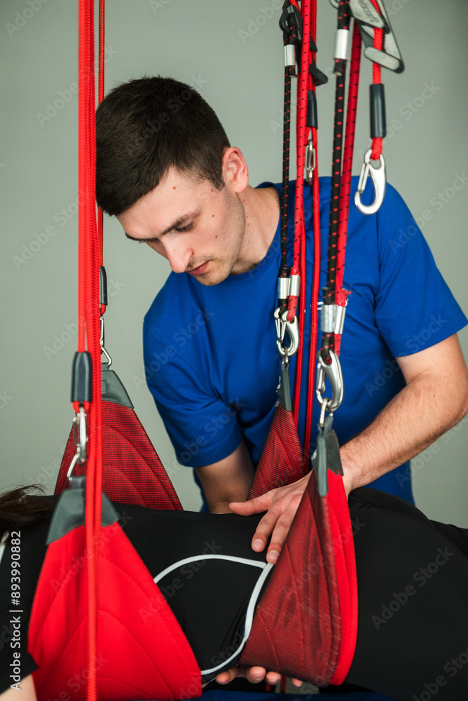 Medical Red Cord physiotherapies to recover from muscle pain. Girl is ...