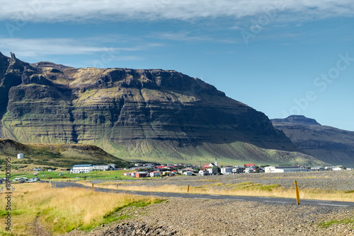 Quaint town nestled by majestic mountains under clear blue sky