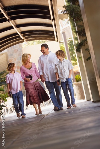 Family Walking With Bibles To Church