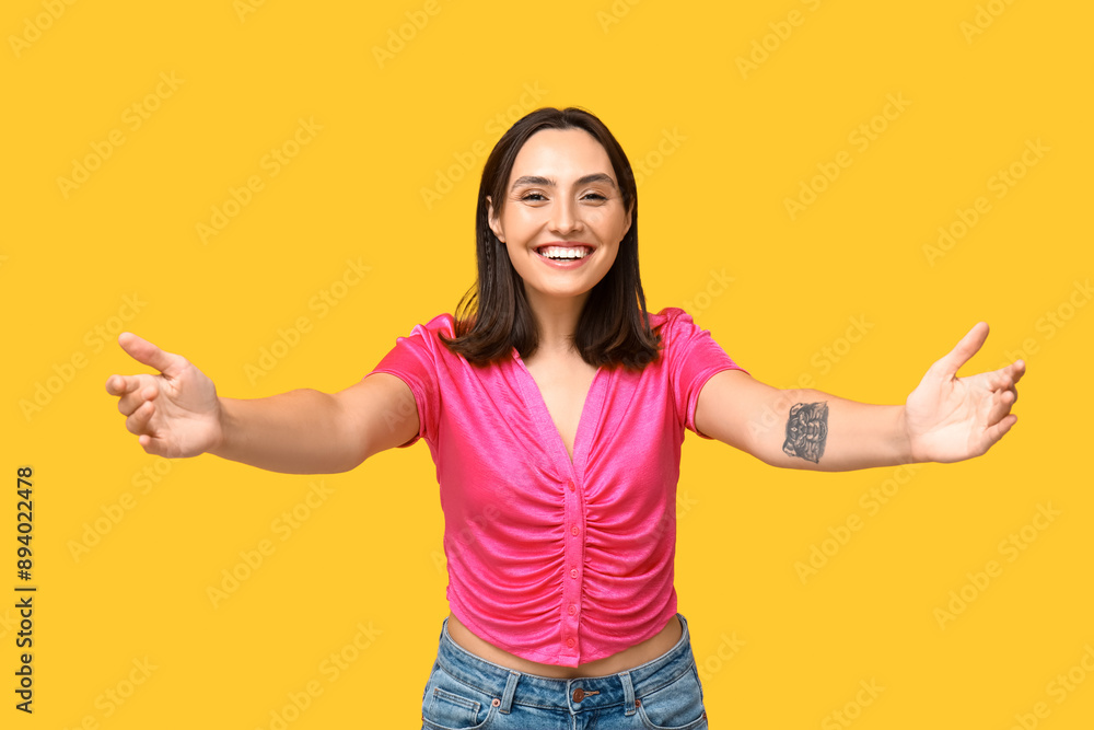 Young woman opening arms for hug on yellow background Young woman opening arms for hug on yellow background