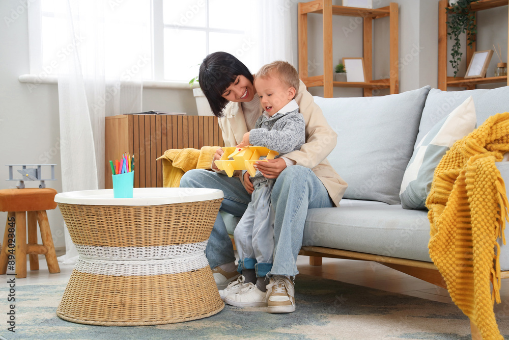Young mother and her little son playing with toy airplane at home Young mother and her little son playing with toy airplane at home