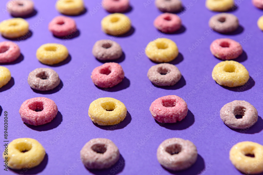 Colorful sweet cereal rings on purple background Colorful sweet cereal rings on purple background