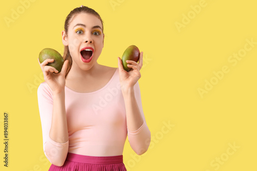 Surprised young woman holdi...