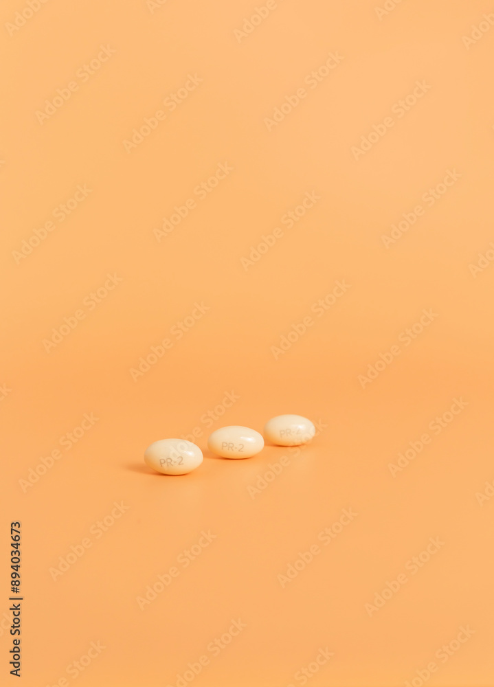 Progesterone Pill, Capsules During Pregnancy On Peach Yellow Background. Copy Space, Dose Of Medications Treats Irregular Menstrual Cycle, Prevents Thicknessing The Lining Of Uterus, Vertical Progesterone Pill, Capsules During Pregnancy On Peach Yellow Background. Copy Space, Dose Of Medications Treats Irregular Menstrual Cycle, Prevents Thicknessing The Lining Of Uterus, Vertical