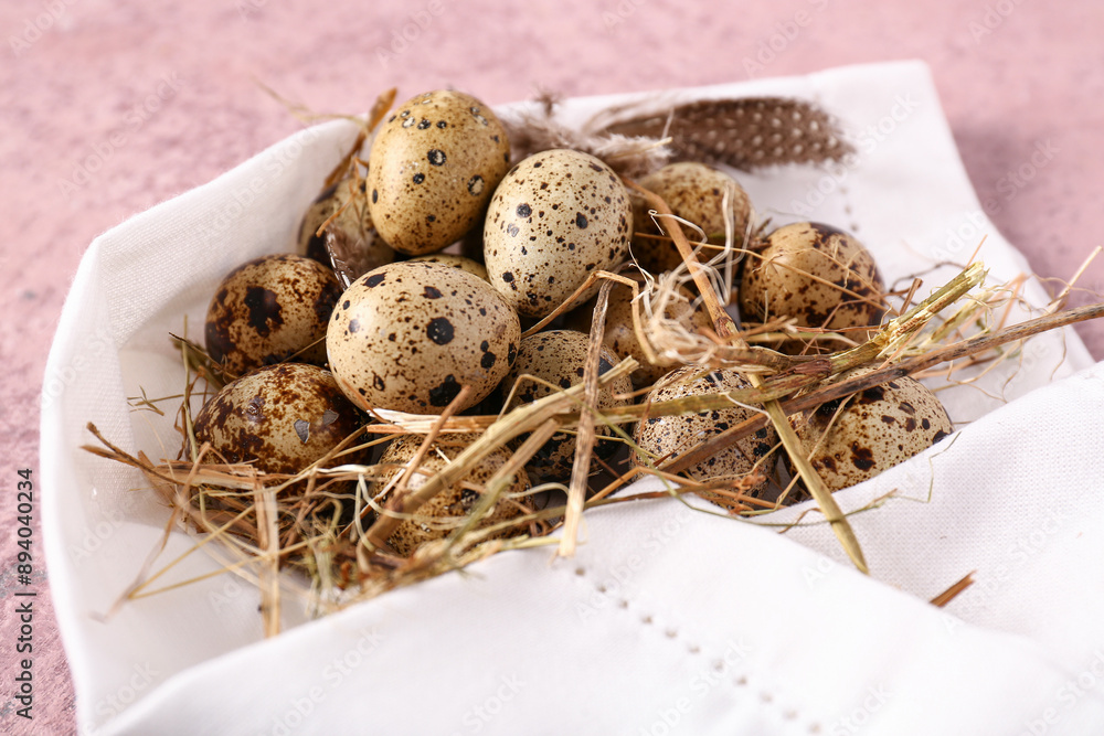 Napkin with quail eggs and feathers on pink grunge background Napkin with quail eggs and feathers on pink grunge background