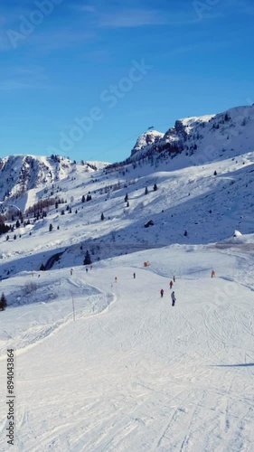 View of a ski resort piste with people skiing in Dolomites in Italy
