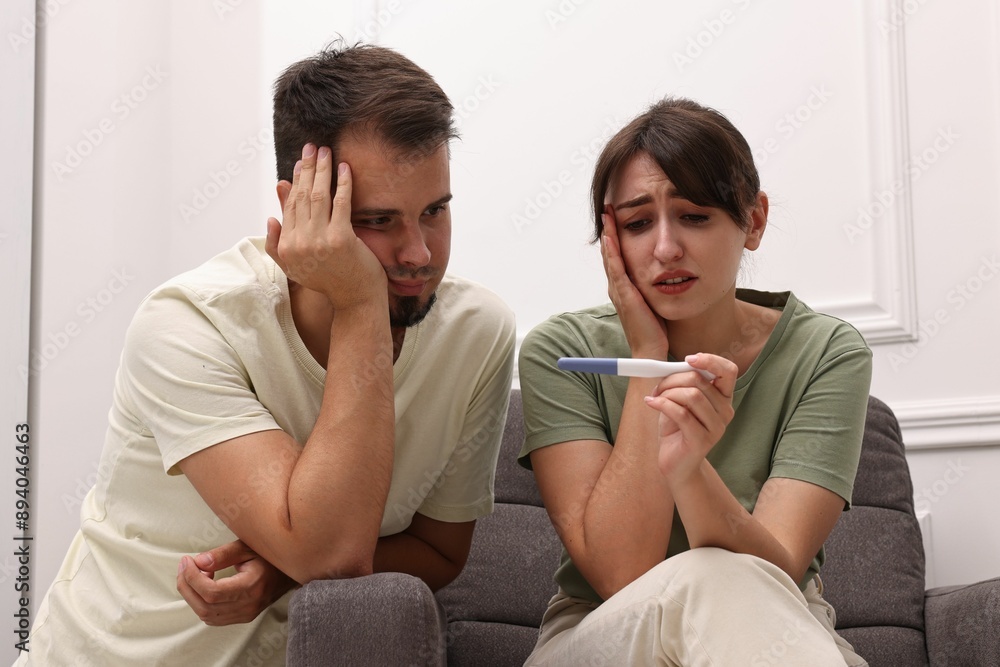 Worried young couple with pregnancy test at home Worried young couple with pregnancy test at home